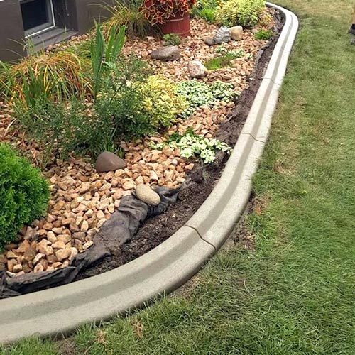 Close up of the lawn edging profile used to border a flower garden around the exterior of a house